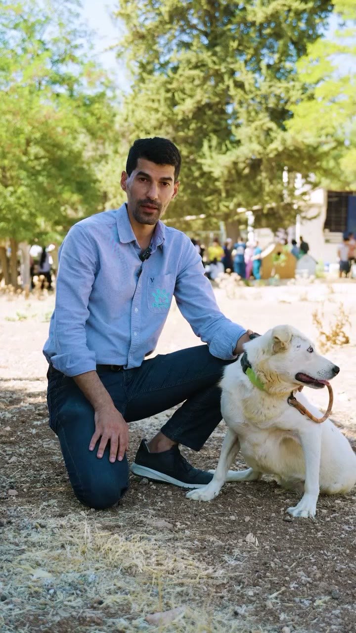 رجل يجلس مع كلب في ملجأ الإيمان